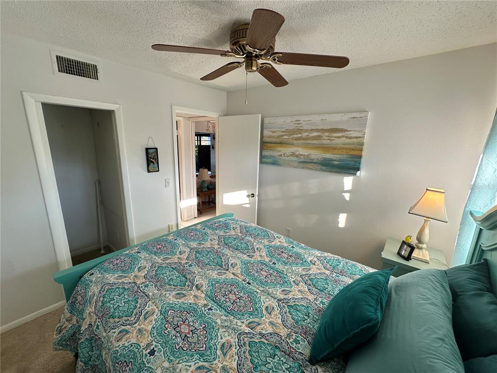 4578 Red Maple, Unit 904 Bradenton, FL 34210 - Photo 26 of 37 a bedroom with a bed and ceiling fan