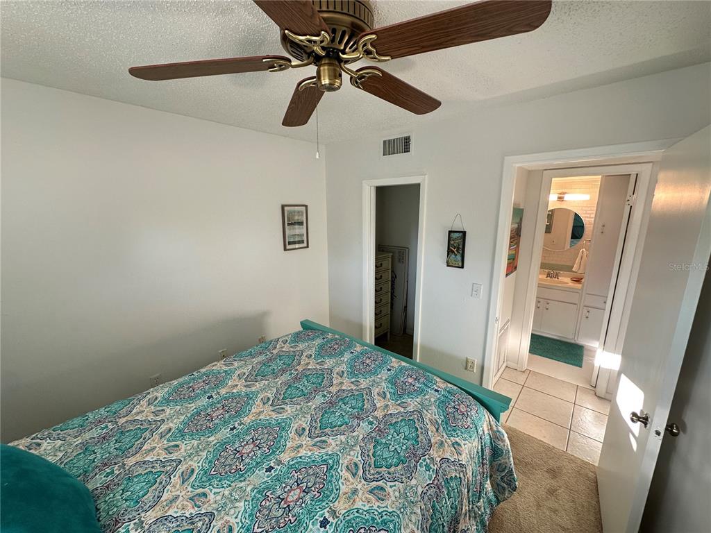 4578 Red Maple, Unit 904 Bradenton, FL 34210 - Photo 27 of 37 a bedroom with a bed and a chandelier