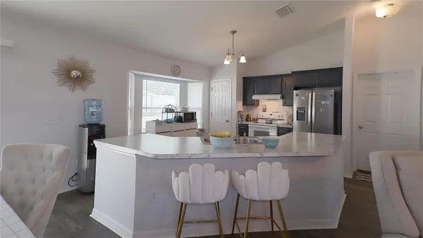 a kitchen with kitchen island granite countertop a counter space a sink appliances and cabinets