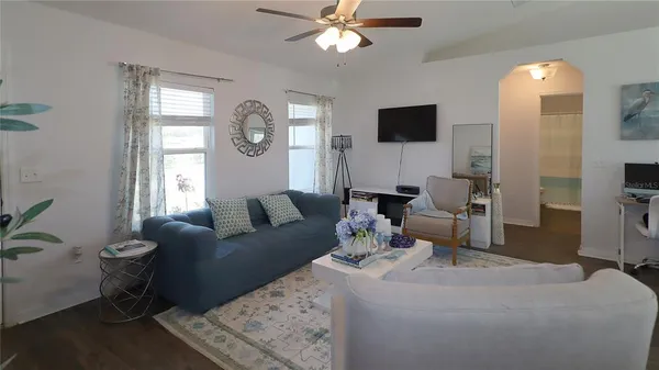 a living room with furniture a large window and a flat screen tv
