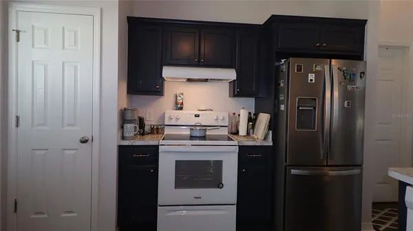 a kitchen with a refrigerator stove and cabinets