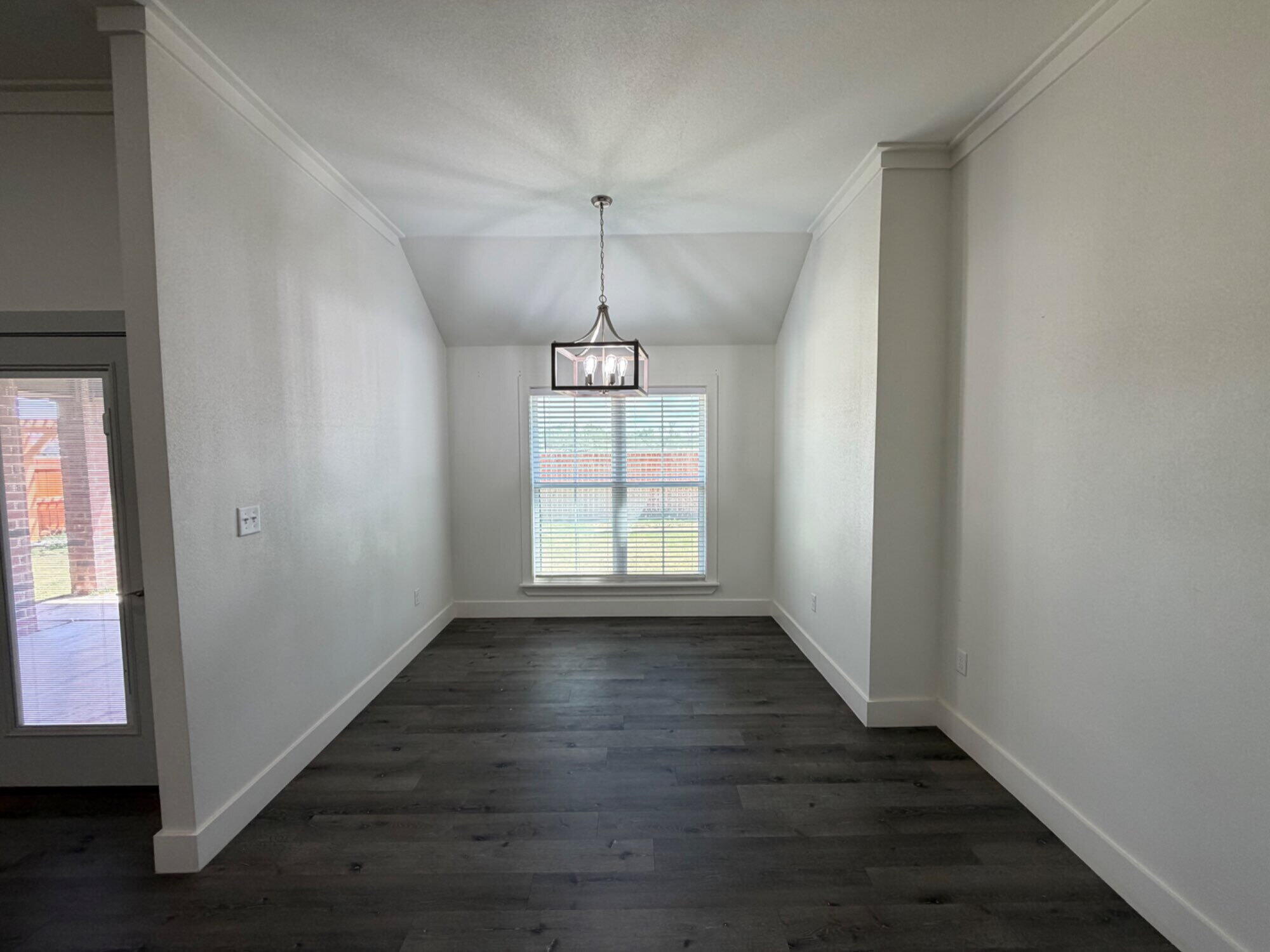 405 Ranger Street Wolfforth, TX 79382 - Photo 7 of 19 a view of an empty room with wooden floor and a window