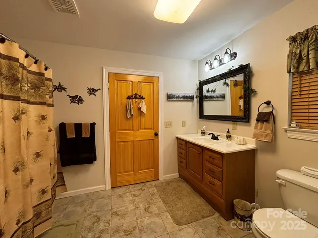 a bathroom with a toilet sink and mirror