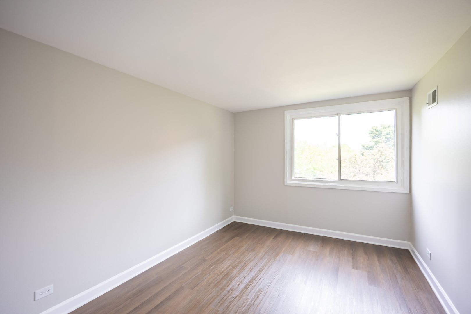 450 Raintree Court, Unit 2B Glen Ellyn, IL 60137 - Photo 19 of 28 an empty room with wooden floor and window