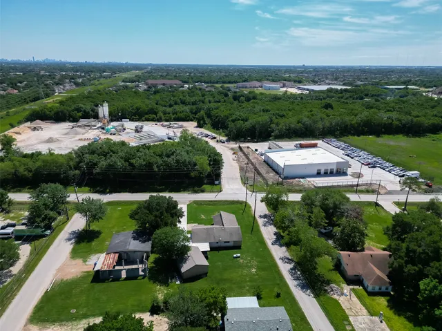 an aerial view of residential houses with outdoor space and trees