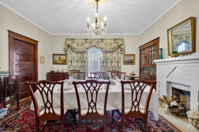 a view of a dining room with furniture a chandelier and wooden floor