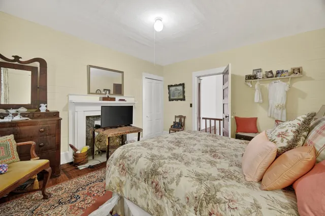 a bedroom with a bed a fireplace and a television