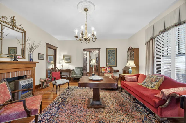 a living room with fireplace furniture and a chandelier