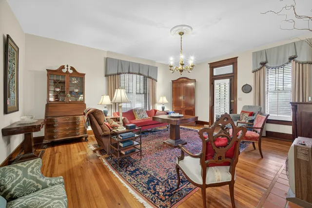 a living room with fireplace furniture and a chandelier