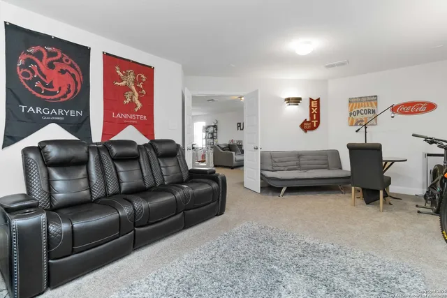 a living room with furniture and a refrigerator