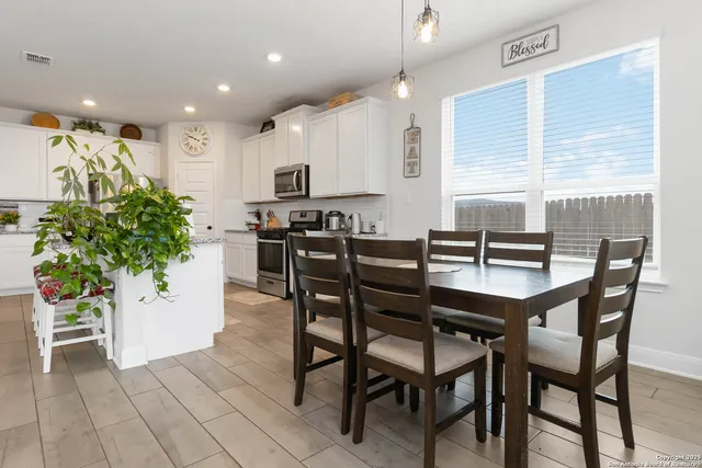 a dining room with furniture and potted plants