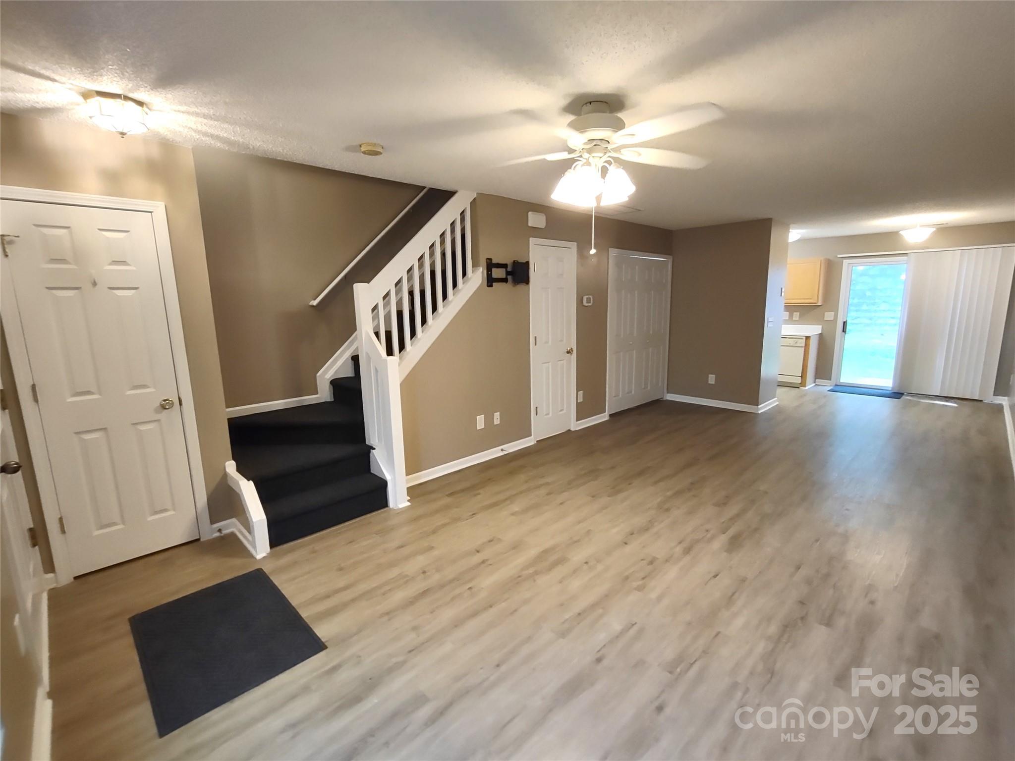 8338 Rudolph Road Charlotte, NC 28216 - Photo 9 of 15 a view of an empty room with wooden floor and staircase