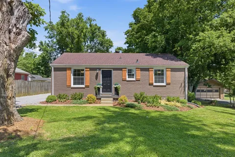 a front view of a house with a garden and yard