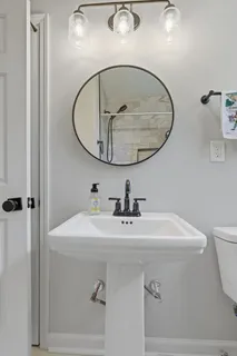 a bathroom with a sink a mirror and toilet