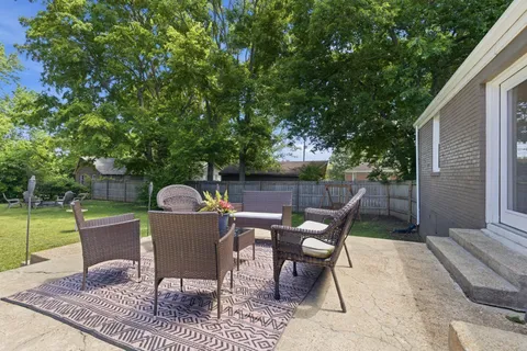 a view of a chairs and table in the back yard of the house