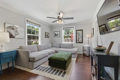 a living room with furniture a flat screen tv and a window