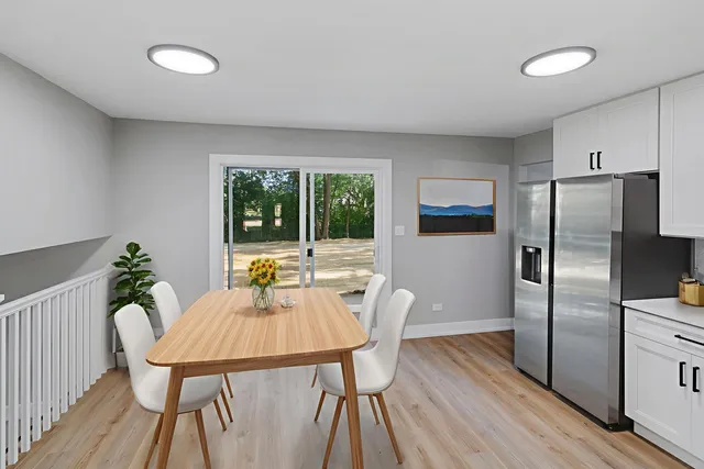 a dining room with furniture a potted plant and wooden floor