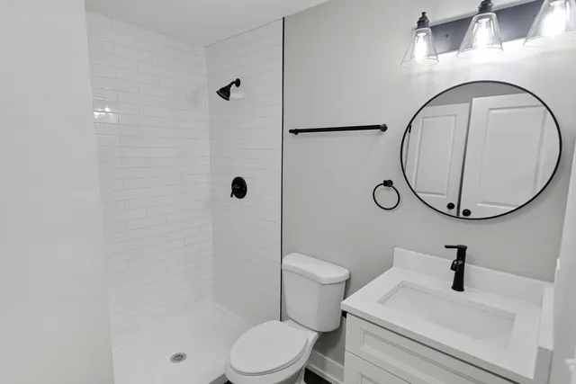 a bathroom with a sink a toilet and a mirror