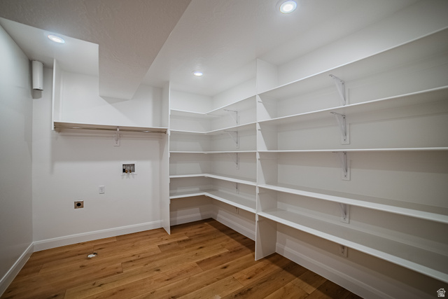 223 South Cottonwood Road, Unit 7501 Vineyard, UT 84059 - Photo 8 of 45 Utility room featuring extensive built-in shelving, wood-finish flooring, recessed lighting, and a clothes hanging rod