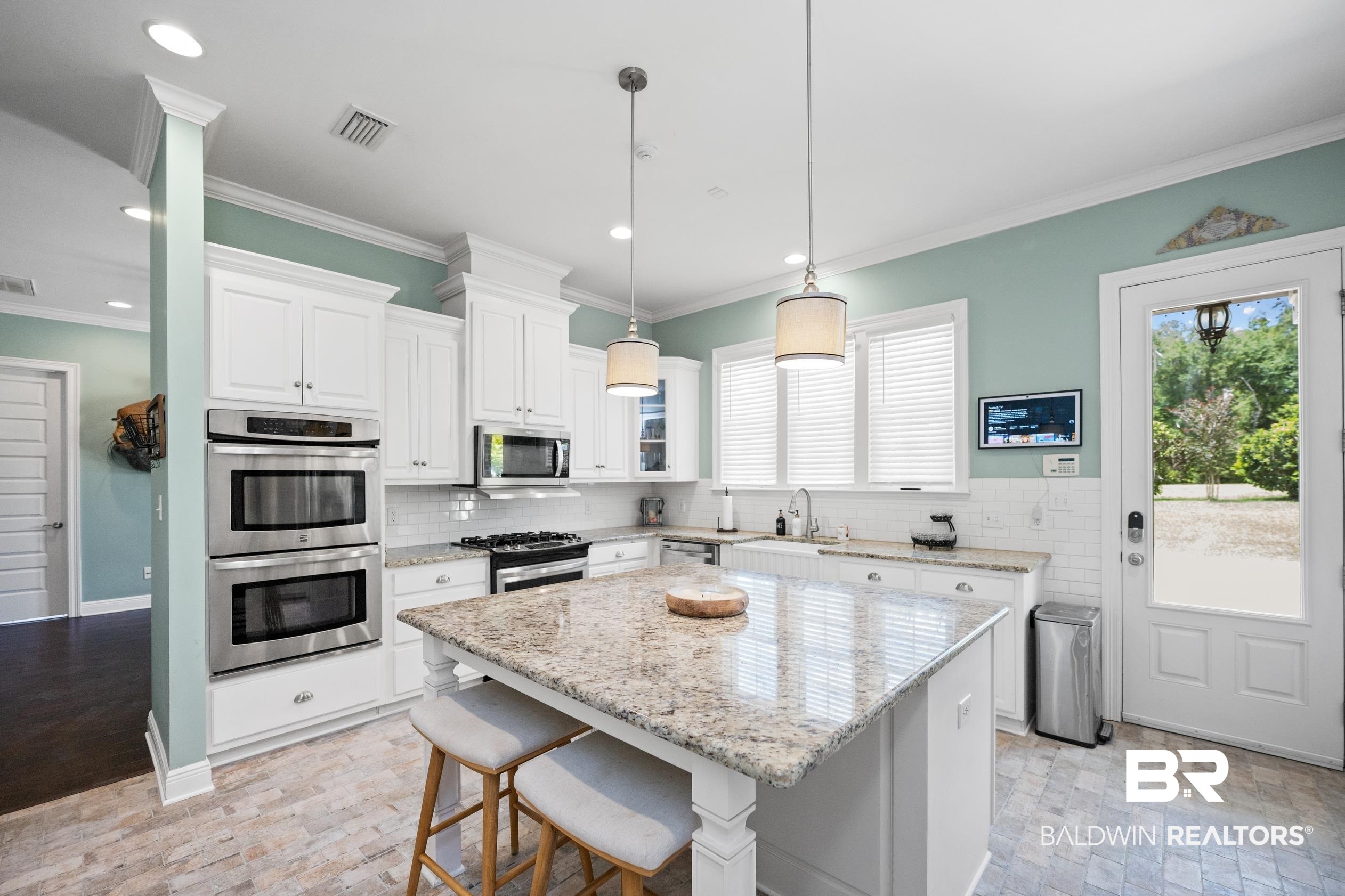 9060 Bromley Road Bay Minette, AL 36507 - Photo 18 of 63 Kitchen with appliances with stainless steel finishes, crown molding, white cabinetry, decorative backsplash, and a kitchen island