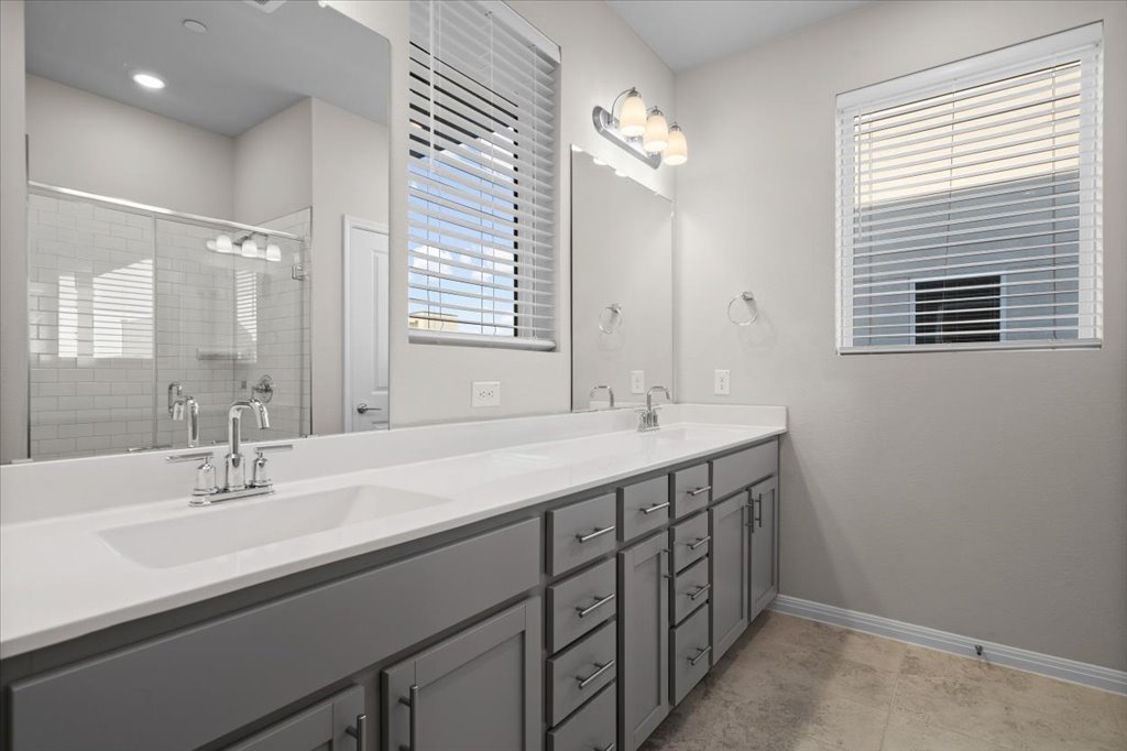 9015 Cattle Baron Path, Unit 705 Austin, TX 78747 - Photo 22 of 35 a bathroom with a double vanity sink and a mirror