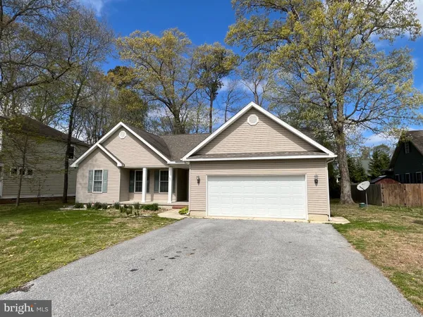 a view of a house with a yard and large tree