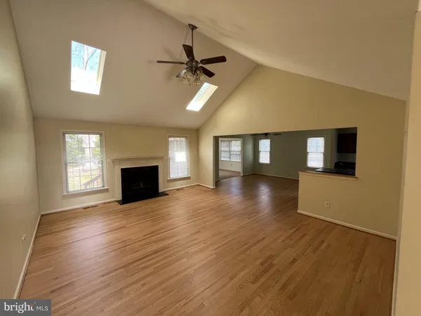 a view of empty room with wooden floor and fireplace