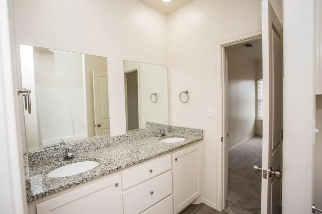 a bathroom with a granite countertop sink and a mirror