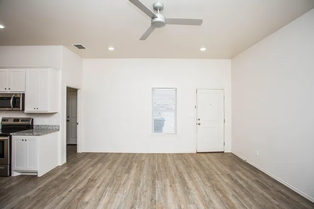 a view of a kitchen with wooden floor and electronic appliances