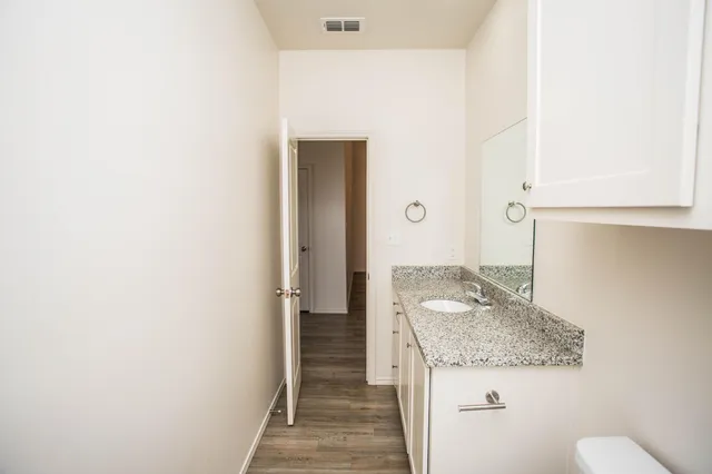 a bathroom with a granite countertop sink and a mirror