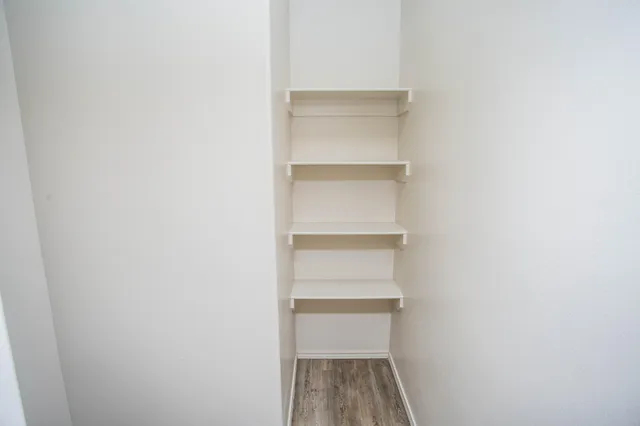 a view of walk in closet with empty racks