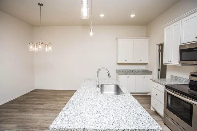 a kitchen with a sink granite counter tops and a stove