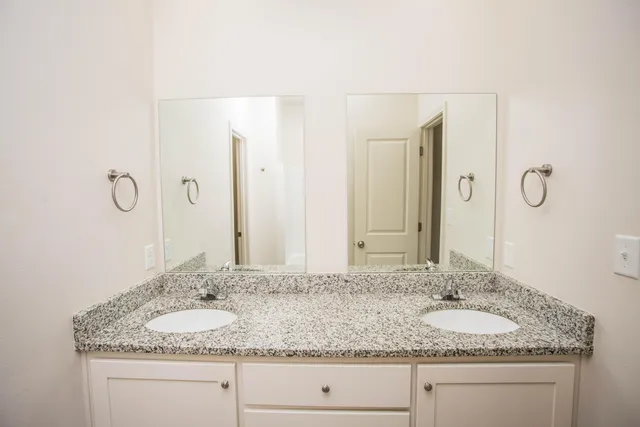 a bathroom with double vanity sinks and a mirror