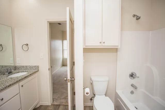 a bathroom with a granite countertop sink toilet and shower