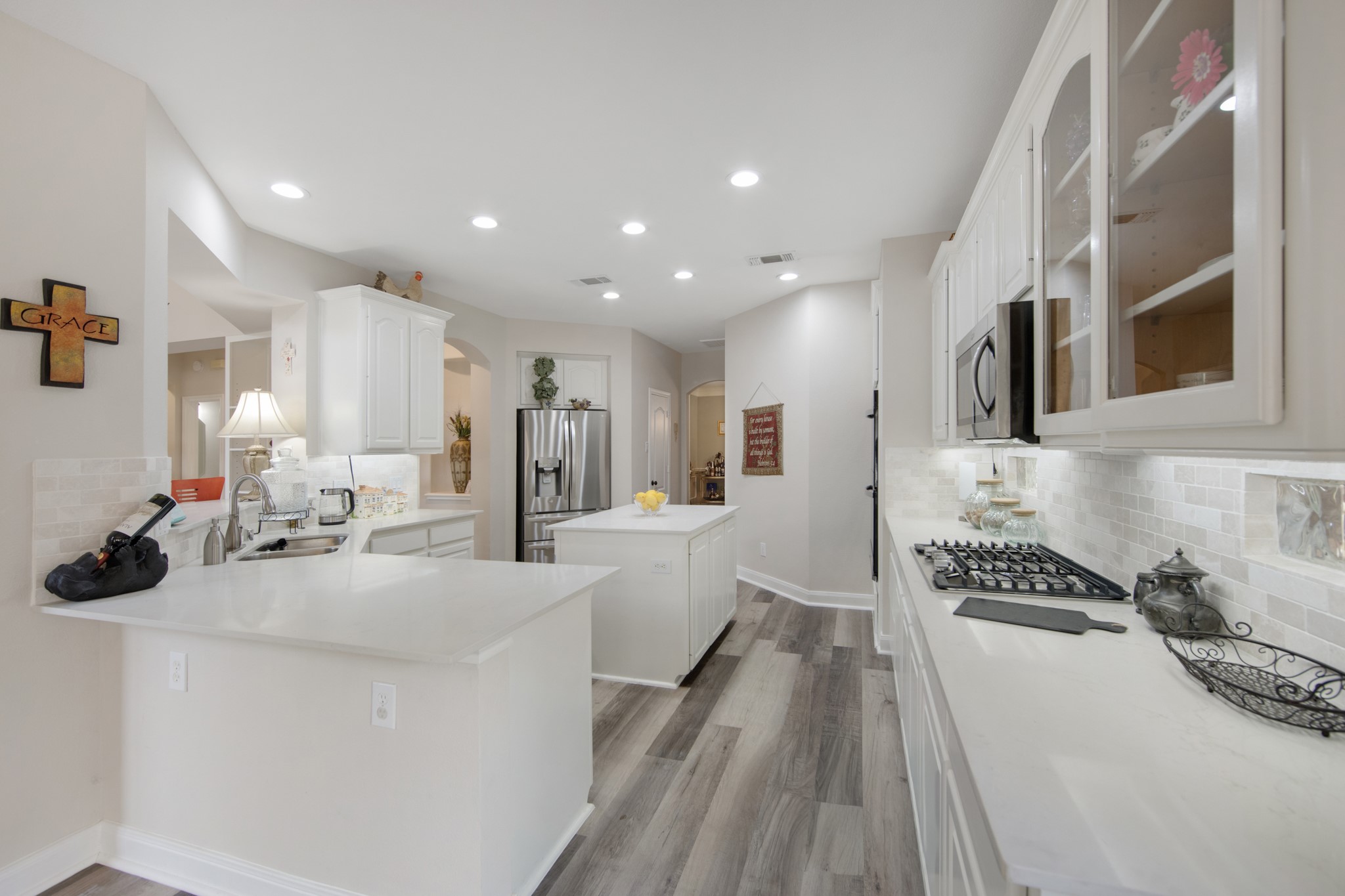 9510 Ashdown Forest Drive Spring, TX 77379 - Photo 7 of 50 KITCHEN – beautifully updated kitchen featuring bright white cabinetry, quartz countertops, and a spacious layout designed for cooking and entertaining. Recessed lighting and abundant counter space make this kitchen both functional and inviting.