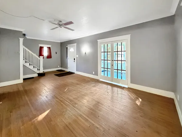 a view of a livingroom with wooden floor and a ceiling fan