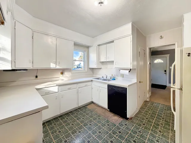 a kitchen with a sink stove and white cabinets