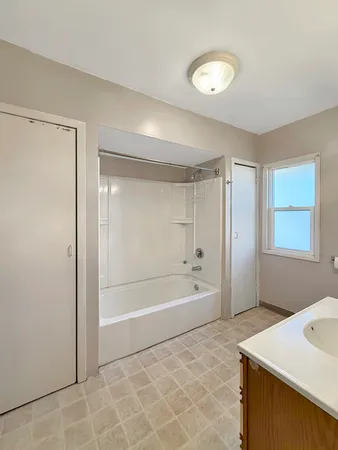 a bathroom with a tub a sink and a shower