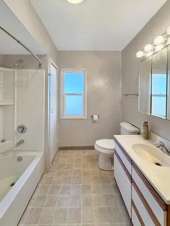 a bathroom with a granite countertop sink a toilet and shower