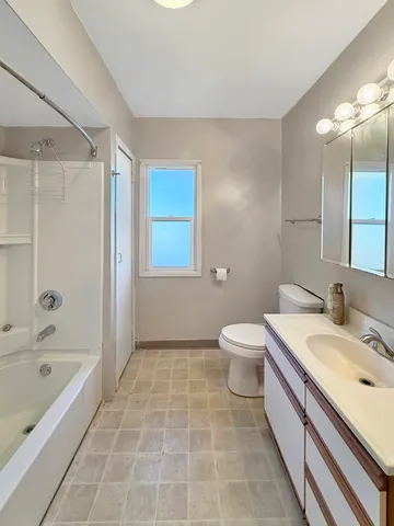 a bathroom with a granite countertop sink a toilet and shower