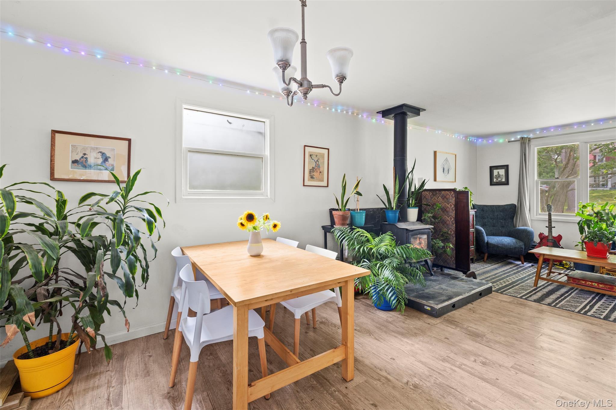 44 Woods Road Tivoli, NY 12583 - Photo 6 of 25 Dining space with a wood stove, a chandelier, and wood finished floors