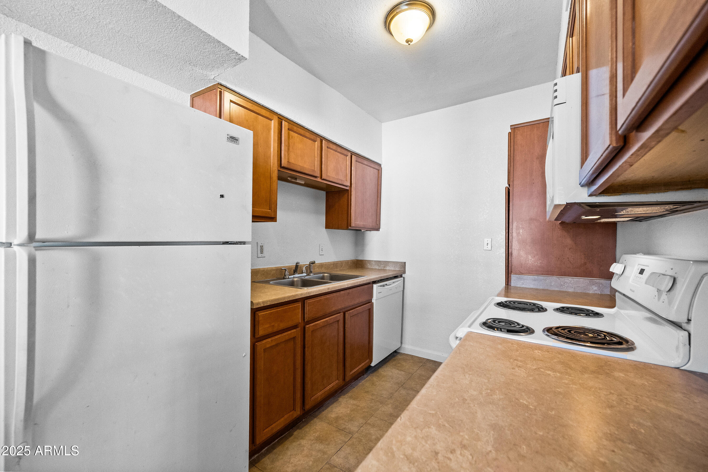 1518 West Colter Street, Unit 4 Phoenix, AZ 85015 - Photo 7 of 26 a kitchen with stainless steel appliances granite countertop a refrigerator a stove and a sink