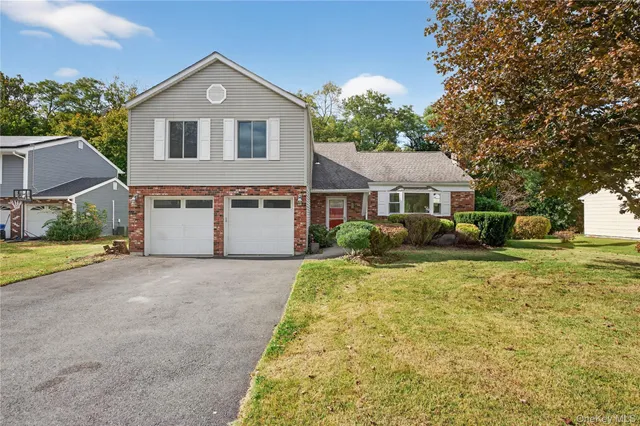 a front view of a house with a yard and trees