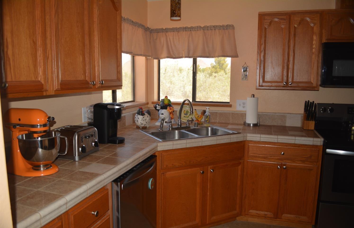 4780 Montiverde Road Mojave, CA 93501 - Photo 3 of 52 a kitchen with stainless steel appliances granite countertop a sink a stove and a microwave with wooden cabinets