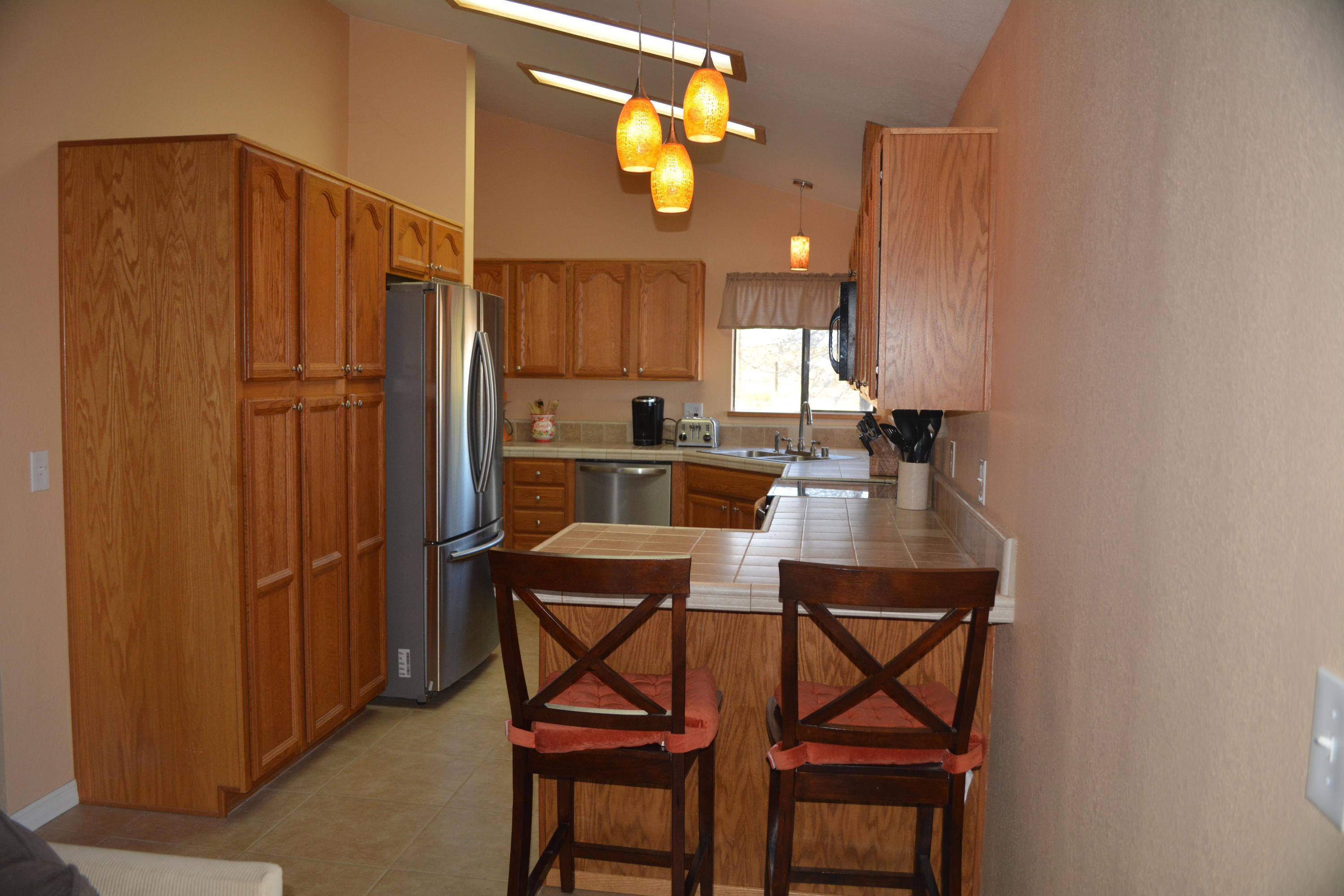 4780 Montiverde Road Mojave, CA 93501 - Photo 6 of 52 a kitchen with a table chairs refrigerator and cabinets