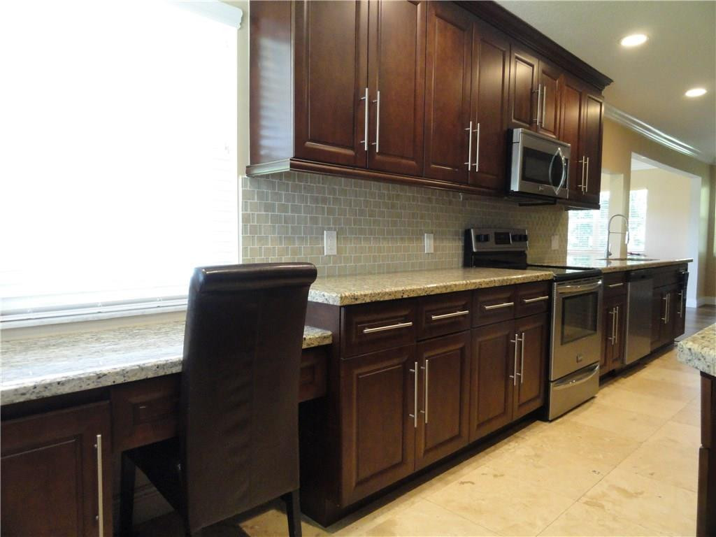 17950 Southwest 55th Street Southwest Ranches, FL 33331 - Photo 4 of 31 a kitchen with stainless steel appliances granite countertop wooden cabinets and a sink