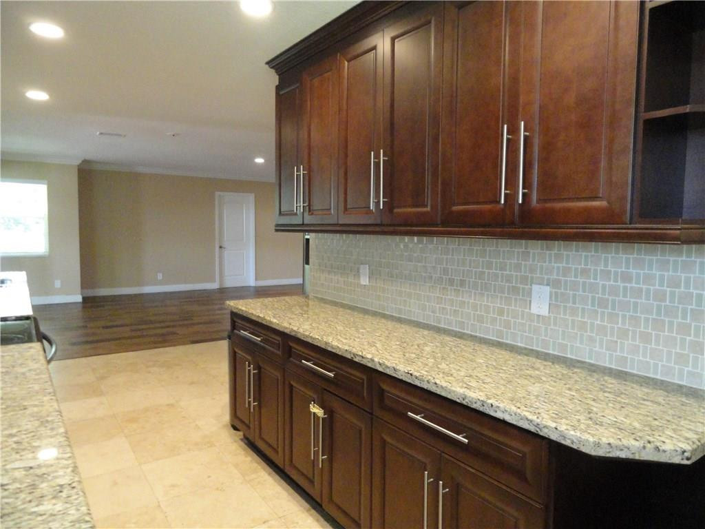 17950 Southwest 55th Street Southwest Ranches, FL 33331 - Photo 6 of 31 a kitchen with granite countertop a sink a stove and cabinets