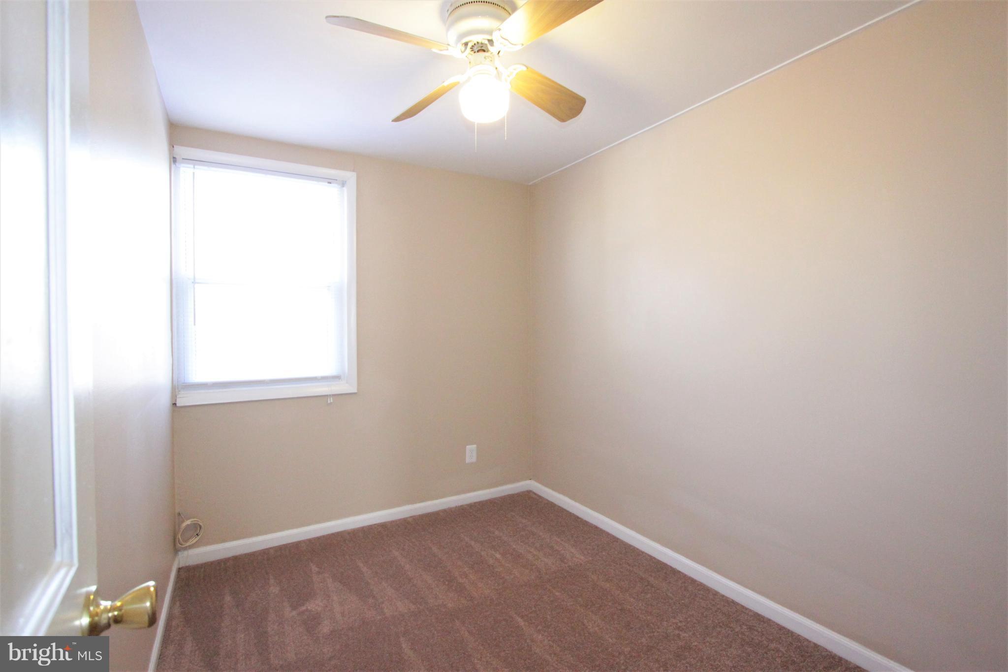 3111 Bero Road Baltimore, MD 21227 - Photo 19 of 25 an empty room with a window and a fan