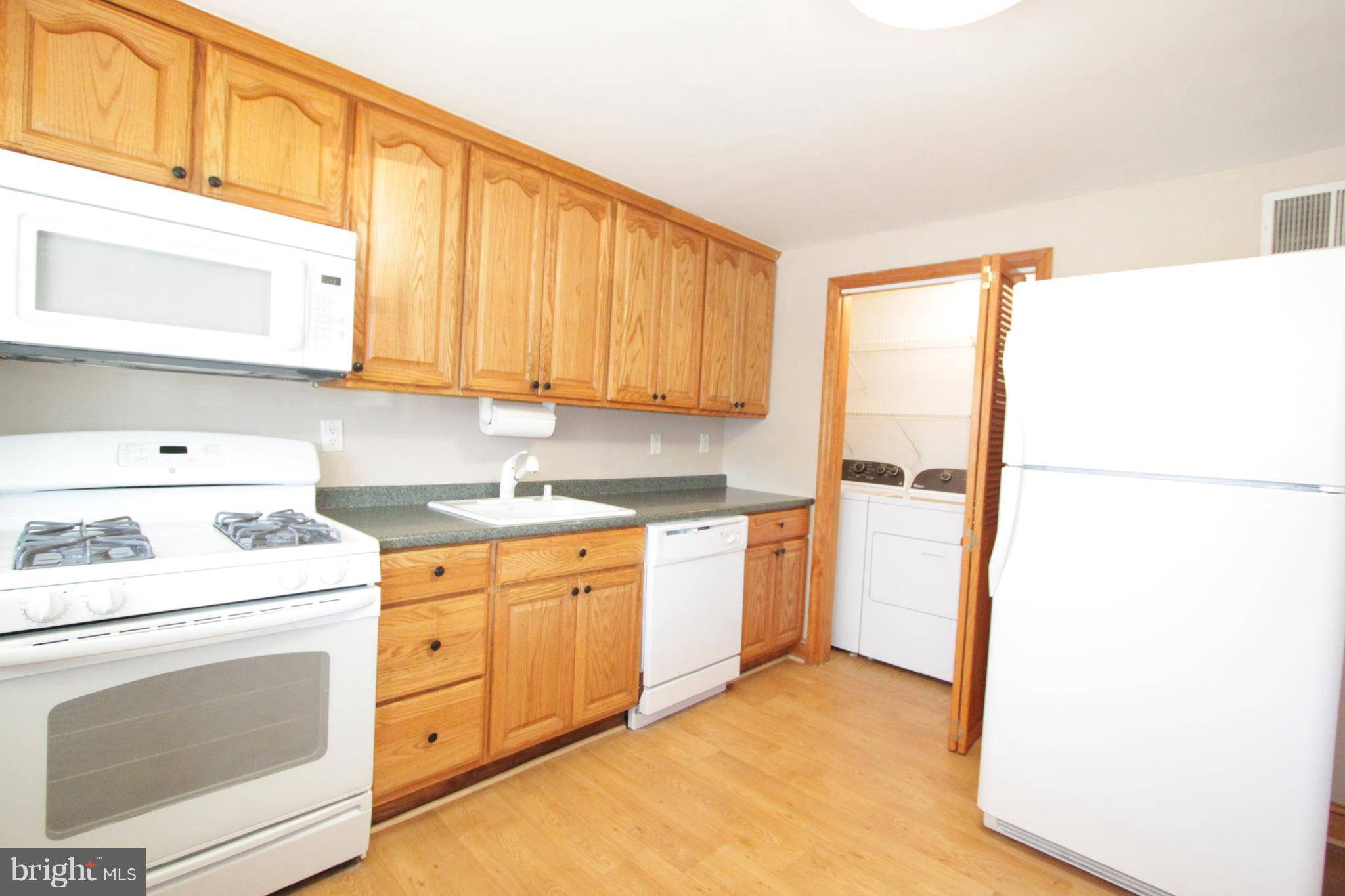 3111 Bero Road Baltimore, MD 21227 - Photo 22 of 25 a kitchen with a refrigerator sink stove and cabinets