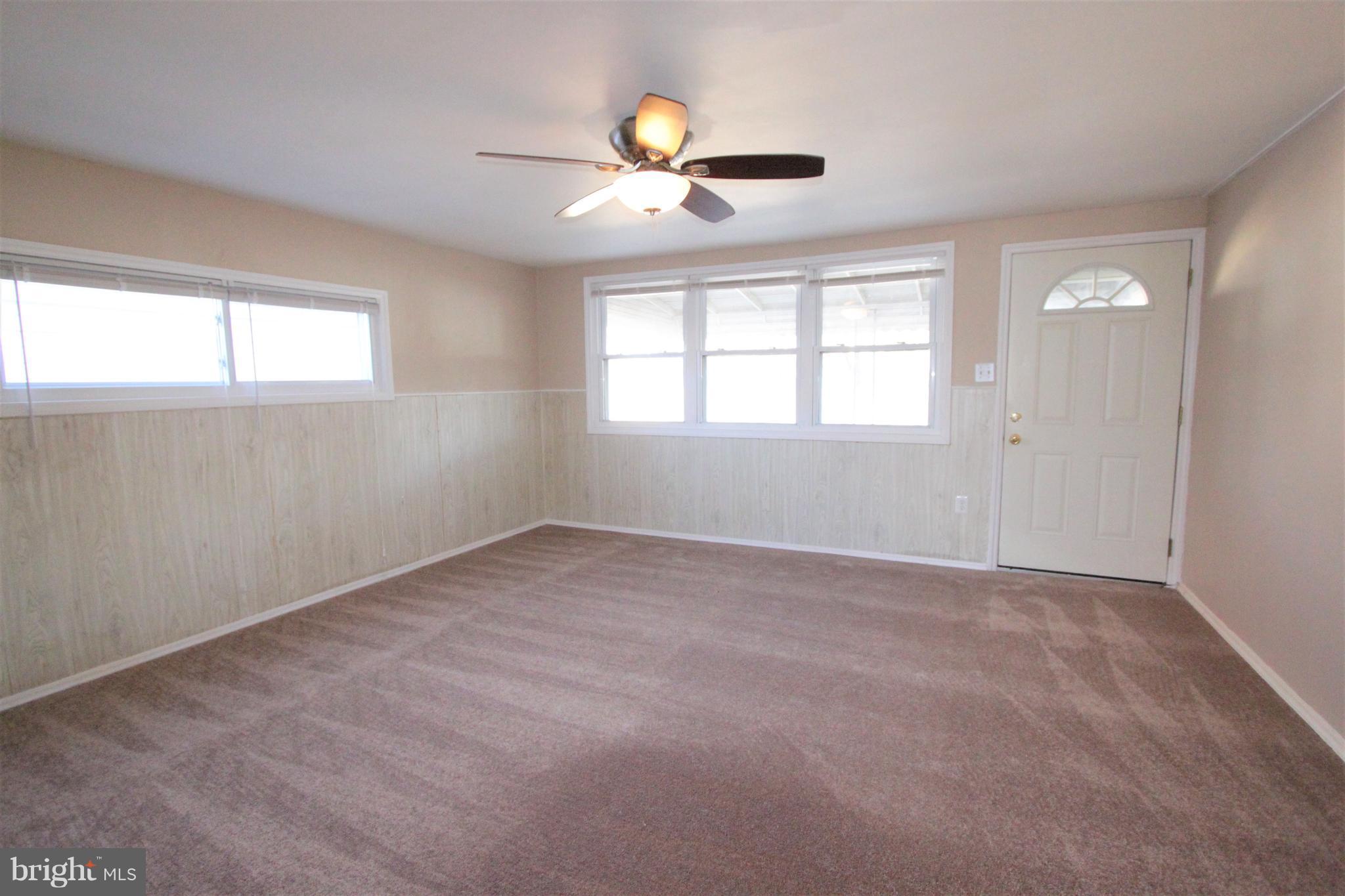 3111 Bero Road Baltimore, MD 21227 - Photo 4 of 25 an empty room with window and chandelier fan